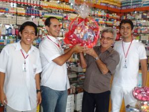 Funcionrios da Farmcia Oriente e Daniel Rayckson entregando a cesta para o senhor Ataydes