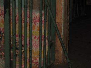 Porta de acesso as celas da delegacia com a barra de ferro cortada 